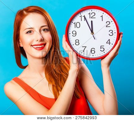 Redhead Girl With Huge Clock On Blue Background.