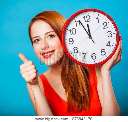Redhead Girl With Huge Clock On Blue Background.