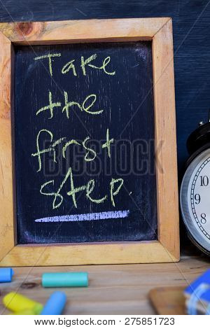 Take The First Step. Back To School Concept. Alarm Clock On Wooden With Blackboard On Background