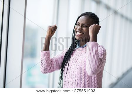 Portrait African Woman With Reised Hands Up Celebrate Success And Goods Results On Pamoramic Window 