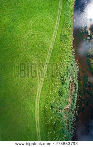 View From Above On The Vivd Green River Shore With Road And Tracks, Algae Flowing In Water