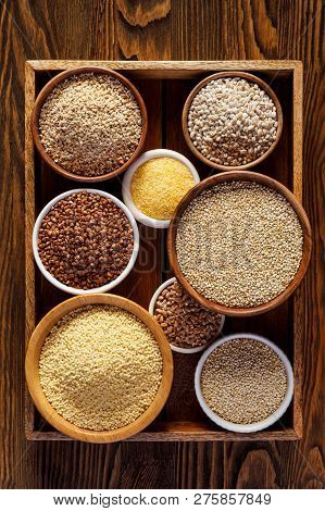 Various Groats, Cereals. Different Types Of Groats In Bowls On A Wooden Background, Top View. Health