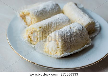 Mini Roll Cake With Vanilla Cream, Coconut And Powdered Sugar.