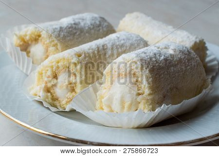 Mini Roll Cake With Vanilla Cream, Coconut And Powdered Sugar.