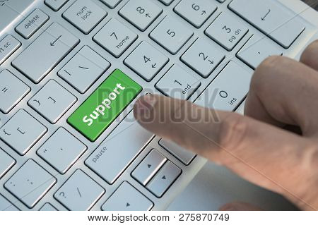 Green Support Keyboard Button. A Male Finger Presses A Color Button On A Gray Silver Keyboard Of A M
