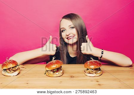 Happy Girl Showing Super By Fingers To Three Humburgers.