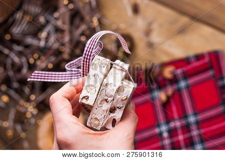 Traditional Italian Sweet From Nougat And Almond For Christmas. Candy In A Female Hand. Free Space F