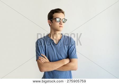Pensive Purposeful Young Man In Sunglasses Looking Into Distance. Thoughtful Guy In Tshirt Crossing 