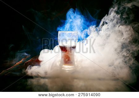 Glass With Red Liquid Around Which Smoke