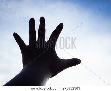The Silhouette Humand Hand Reaching To The Sky
