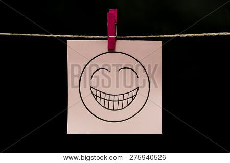 Copy Space. White Sticker. On Face An Expression Of Gaiety. The Paper Is Attached To The Rope With A