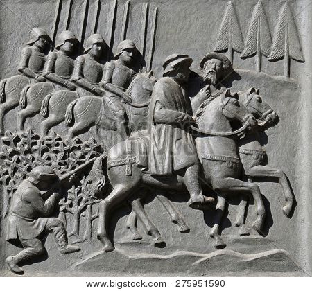 ZURICH, SWITZERLAND - JUNE 23, 2018: Zwingli riding on the side of the mayor Diethelm Rois to the disputation in Bern, relief on the door of the Grossmunster (