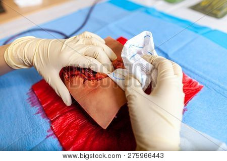 German Military Medic Practice Bleeding Control On A Wound Dummy