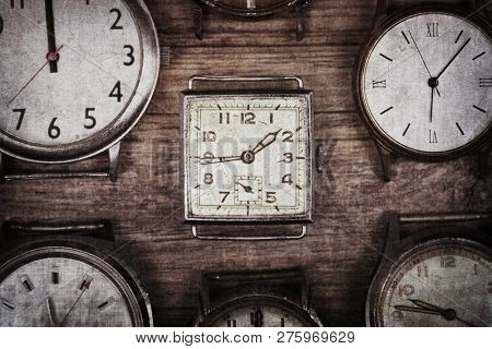 A selection of retro and antique watches over old wood background. Textures to look like an aged photo.