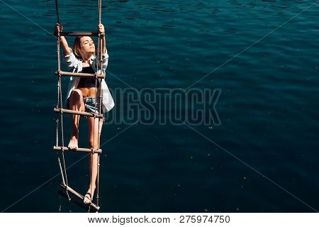 Her Ambition Is Too Far. Pretty Woman Climb Jacobs Ladder To The Top. Sensual Woman Hang On Rope Ove