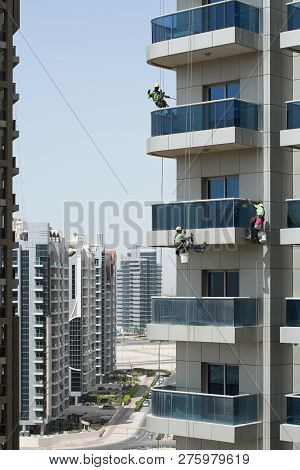Three High-rise Workers Wash Windows Of A High-rise Building In Dubai