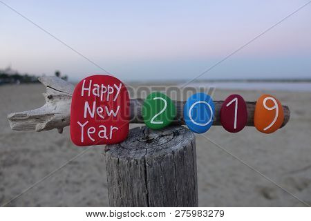 Happy New Year 2019 With Painted Stones On A Wood And Beach Background
