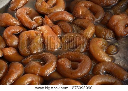 Close up of brown color paneer jabeli also known as chanar jalebi in Bengali soaked in sugar syrup, 