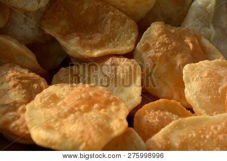 Close up of poori, deep fried bread kept in a dish