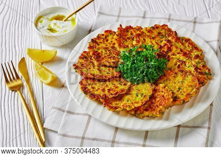 Sweet Onion Fritters Or Jewish Latkes With Parsley And Rice, Served On A White Plate With Lemon And 