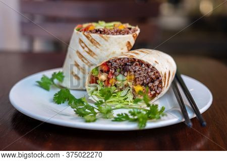 Vegan Burrito. Sliced Up Raw Food Wrap With Vegan Ingredients On A Plate