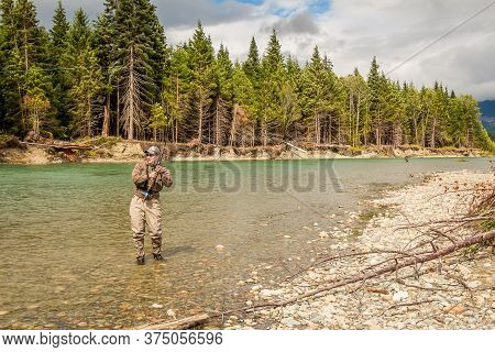 Kitimat, British Columbia, Canada - July 27th, 2015: A Sport Fly Fisherman Hooked Into A Salmon On T