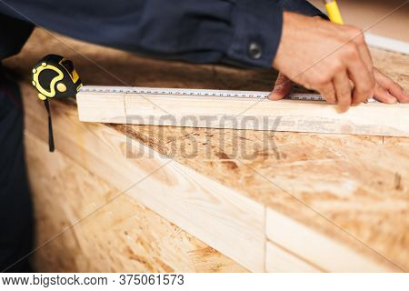 Close Up Foreman Hands Using Measuring Tape And Pencil In Worksh