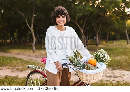 Pretty Girl On Classic Bicycle And Basket Full Of Fruits And Wil