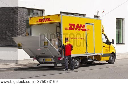 Delivery Man In Uniform Opening Tailgate Loader On A Dhl Lorry. Courier, Parcel, And Express Mail Se