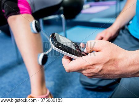 Physical Therapist Install Electrostimulator On The Muscles Of The Legs