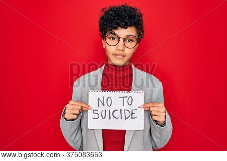 Beautiful african american afro businesswoman holding banner with no to suicide message with a confident expression on smart face thinking serious