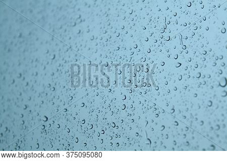 Drop Of Water On The Glass. Splash Of Rainwater Forms A Beautiful Circle Of Water On The Glass