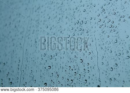 Drop Of Water On The Glass. Splash Of Rainwater Forms A Beautiful Circle Of Water On The Glass