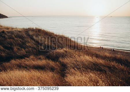 Sunset On The Sea Coast. Hills And Beach. Summer Holidays