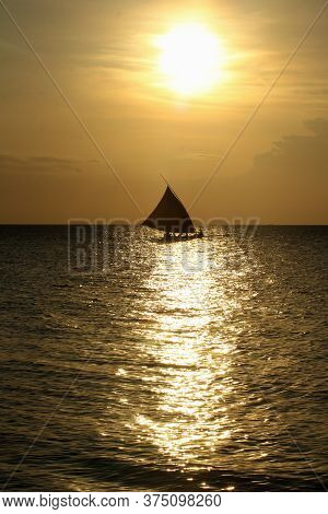 Silhouette Of A Fishing Boat At Dusk On The North Coast Of The Island Of Java