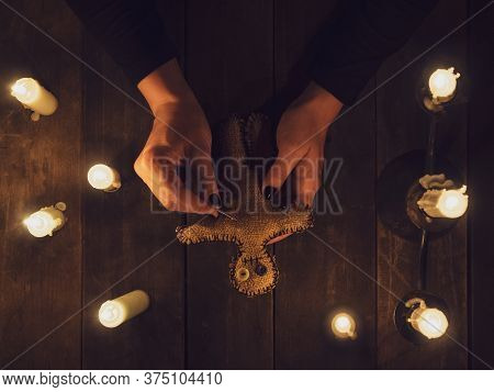 A Witch In The Dark Holds A Voodoo Rag Doll Surrounded By Candles, Flat Lay. The Concept Of Black Ma