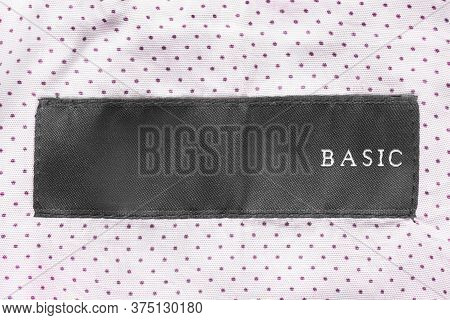 Clothing Label Says Basic On Pink Polka Dots Tetile Background