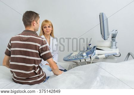 The Lady Ultrasunography Doctor Is Explaining To The Patientat Divice, In Medical Office