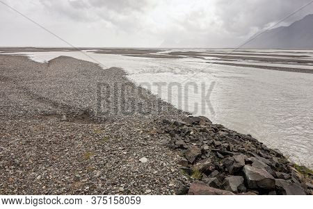 Gravel And Stone Shore Near The River And Ocean In Stafafell Area In Iceland, Europe