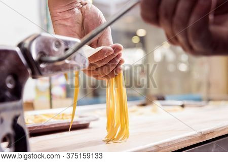 Chef Rolling Dough With A Pasta Machine. Pasta Maker Machine.