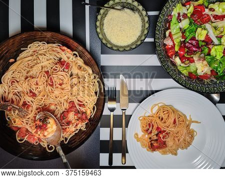Home Italian Pasta With Shrimps Closeup Served On A Table With Colourful Salad & Parmesan. Top View 