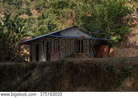 Buddhist Praying Flags Attatched To A Small House In A Nepalese Village, Annapurna Circuit