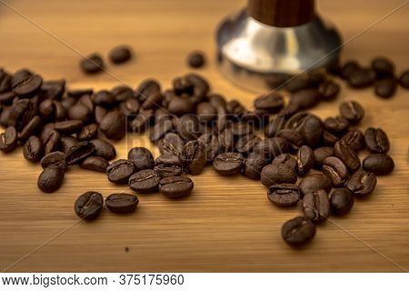Various Coffee Beans On Wooden Table With Tamper