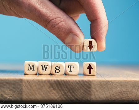 A Businessman Exchanges A Wooden Cube With An Up Arrow For A Wooden Cube With An Down Arrow. German 