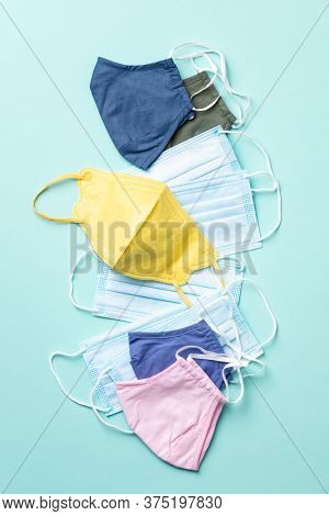 Various Face masks for protection virus, flu, coronavirus, COVID-19. Medical masks and cotton reusable masks on blue background. Flat lay, top view
