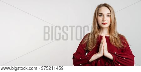 Please, Help Me. Emotive Pleased European Girl With Long Blonde Hair, Keeps Hands In Praying Gesture