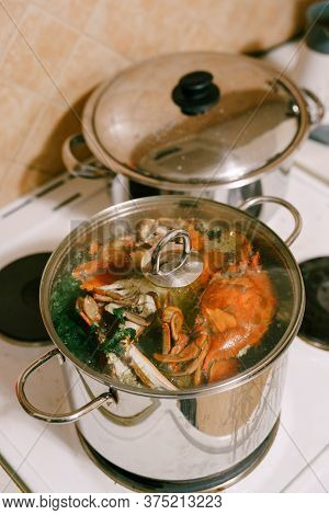 Red Boiled Crabs In A Saucepan. Blue Crabs Are Cooked In A Saucepan With A Glass Lid.
