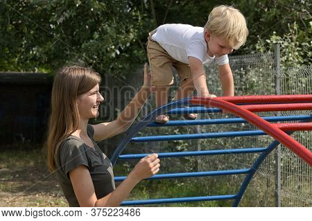 A Boy With Cochlear Implants Playing In Summer Park