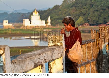 Mandalay, Myanmar - Nov 12, 2019: Smoking Man At U Bein Bridge In Amarapura,mandalay Myanmar