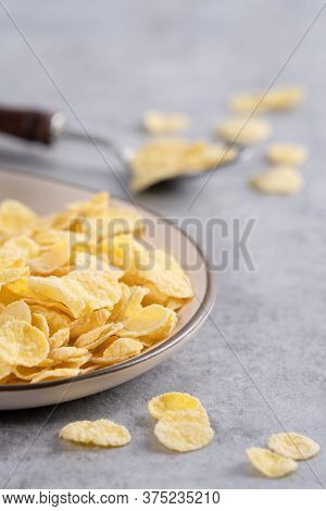 Corn Flakes Bowl Sweeties With Milk On Gray Cement Background, Close Up, Fresh And Healthy Breakbast